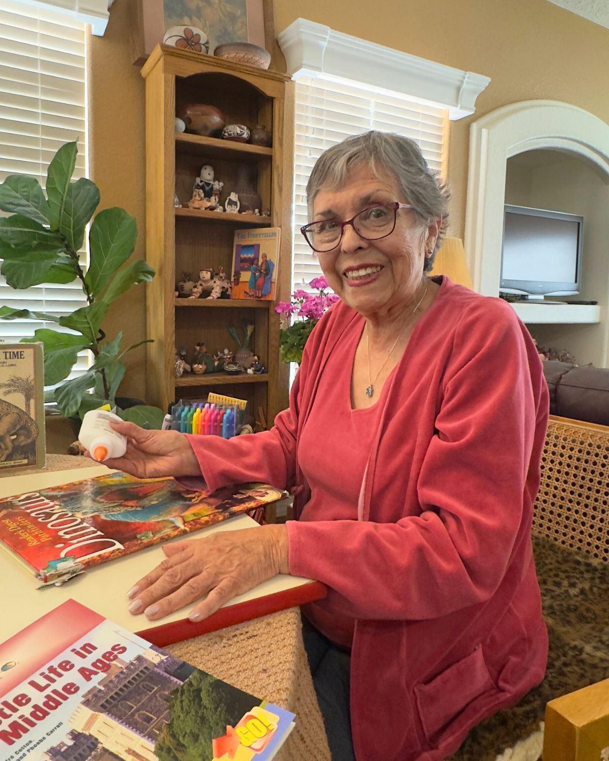 Picture of Albuquerque literacy volunteer Olivia Rivera sitting at her table repairing books