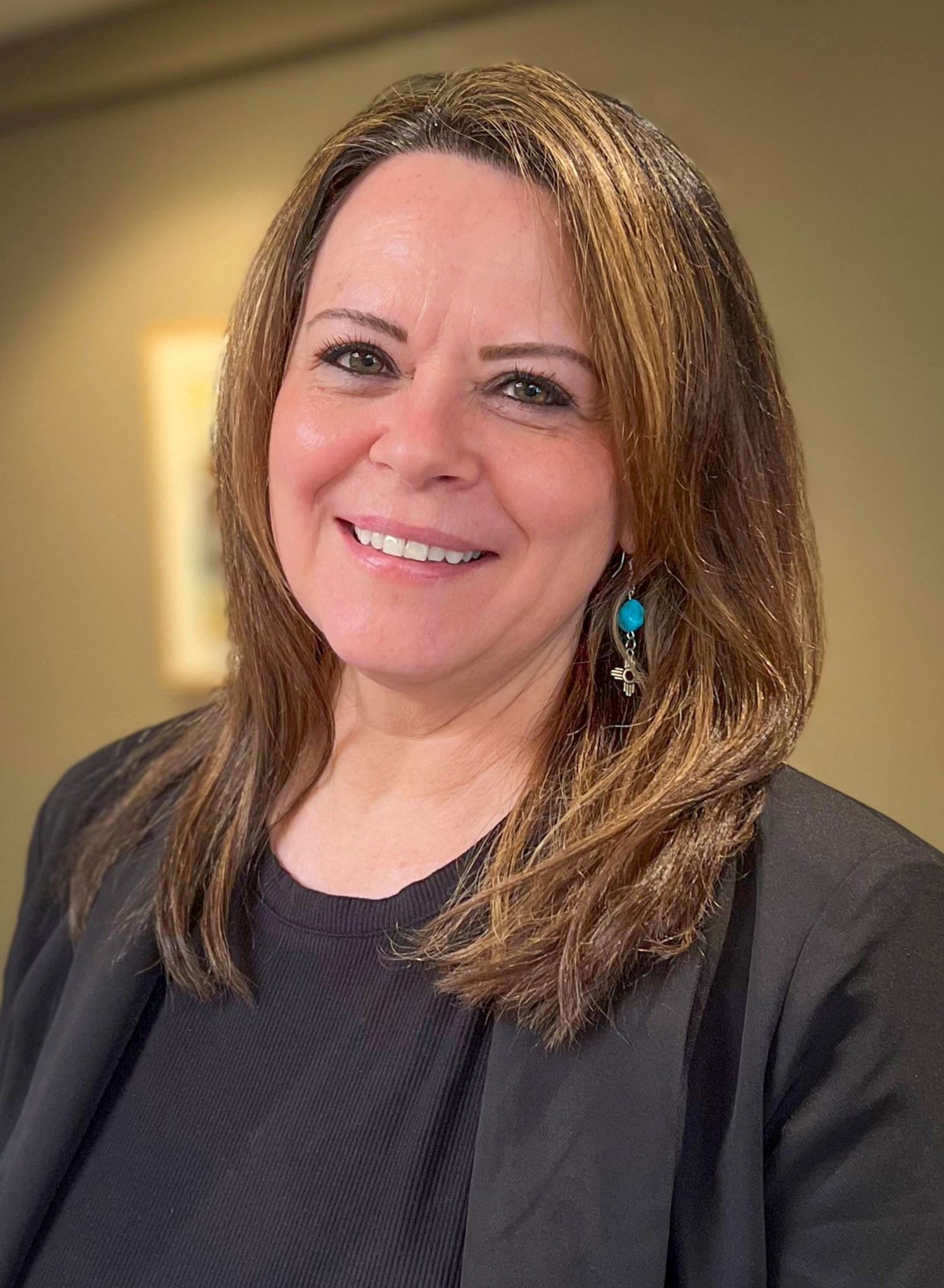 Picture of a woman wearing business attire smiling at the camera