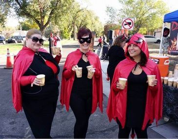 Women dressed in Halloween costumes handing out water at a bicycling event