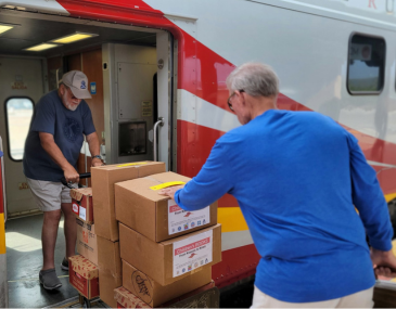 Read to Me Volunteers Loading Books on Train