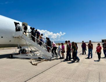 Picture of students boarding a small aircraft on the tarmac at the Albuquerque Airport