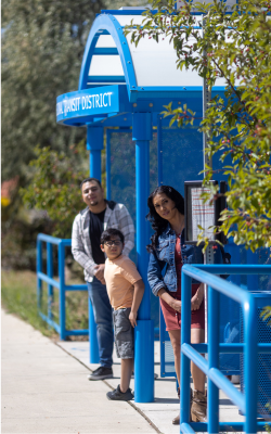 A family waiting at a Blue Bus stop in northern New Mexico