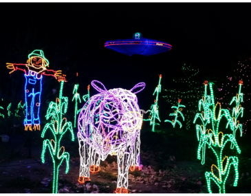 Picture of a light sculpture depicting a corn field with a cow a scarecrow and a UFO 