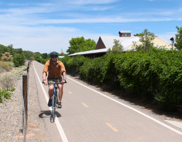 Man riding a bike on a trail in the Albuquerque Bosque