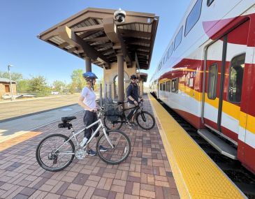 Picture of two people on bicycles boarding the Rail Runner train at the Downtown Bernalillo Station