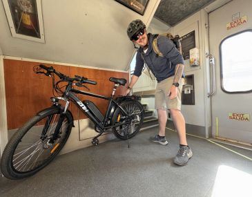 Picture of a man loading an electric bike onto the Rail Runner train