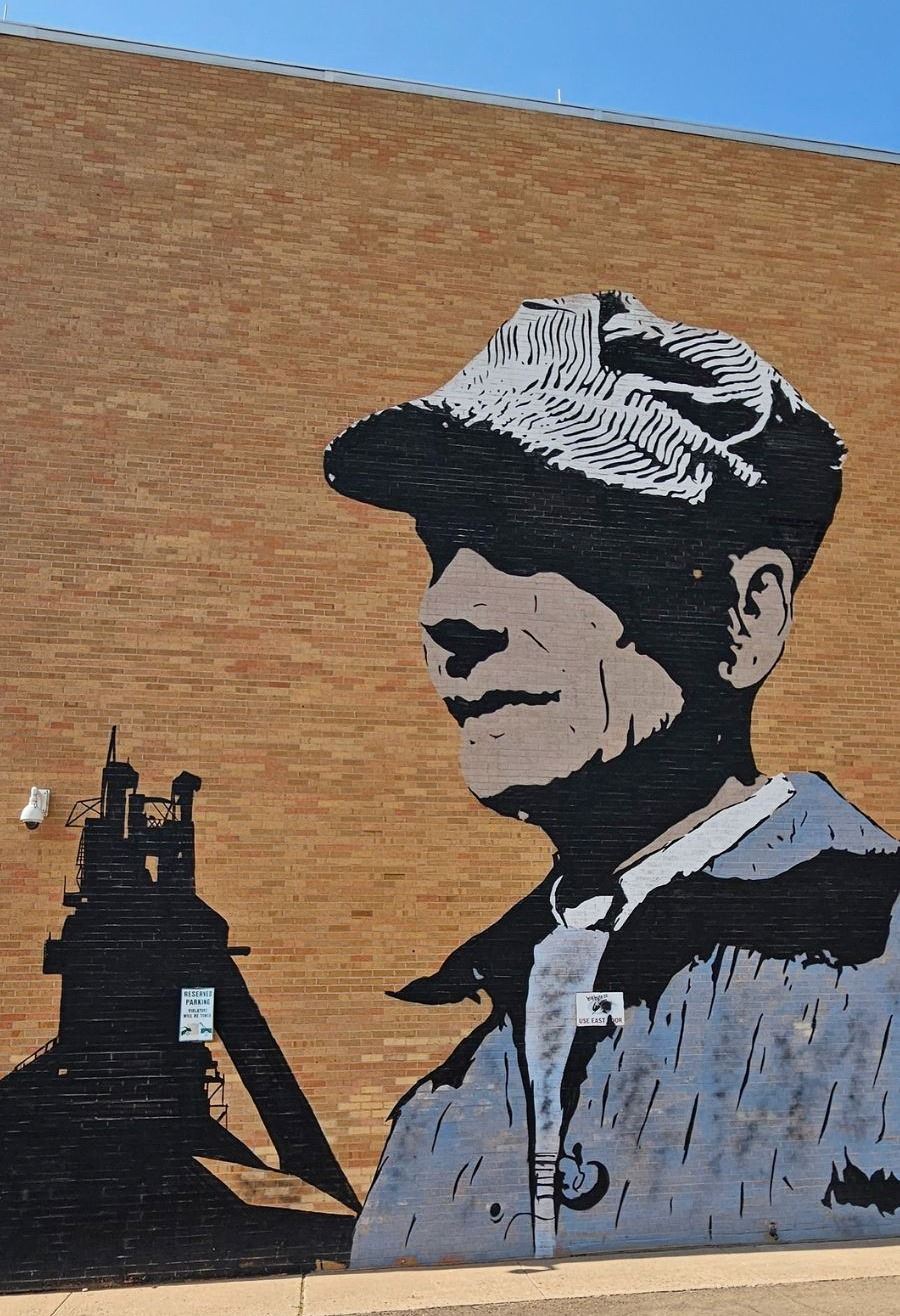 Picture of a mural of a railroad conductor on the side of a building