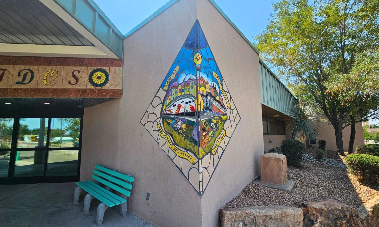 Picture of a colorful mosaic on the side of a building featuring the Rail Runner train
