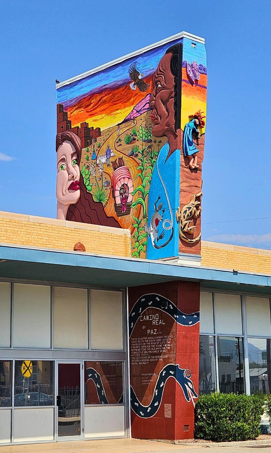 Picture of a public art piece on a building featuring various types of transportation